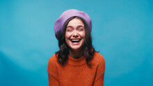 Excited Woman In Warm Sweater And Beret Laughing Isolated On Blue