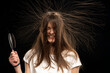 Woman with static long hair standing on end, isolated on black background.