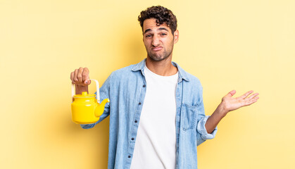 Wall Mural - hispanic handsome man feeling puzzled and confused and doubting. teapot concept