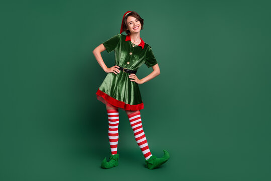photo of funny positive cheerful helper lady hands hips wear elf costume hat stockings isolated gree