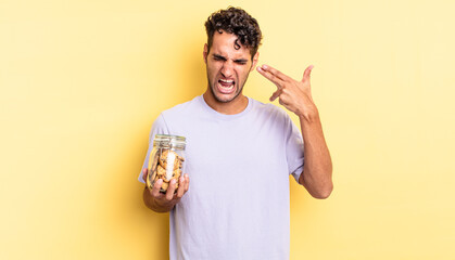 Wall Mural - hispanic handsome man looking unhappy and stressed, suicide gesture making gun sign. cookies concept