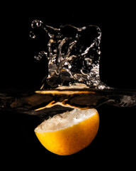 Sticker - Mesmerizing shot of a lemon in a glass of water isolated on a black background