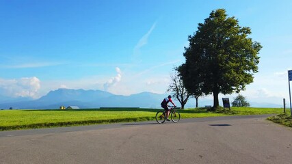 Poster - A footage of a cyclist riding a byicycle along the road with beautiful landscape