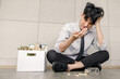 © SHUTTER DIN - young asian businessman sitting on the floor in office and stressed sad after being laid off from his job