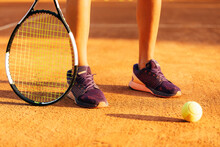 Female Tennis Player With Racket And Ball Standing At Sports Court