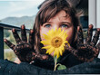 © ADDICTIVE STOCK - Dirty girl having fun against blooming Helianthus growing in soil