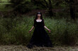© ADDICTIVE STOCK - Witch in black dress in dark forest