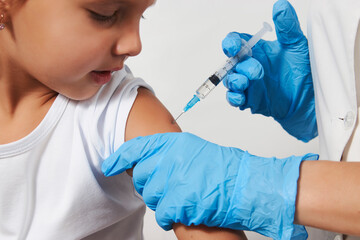 Wall Mural - Female doctor injecting vaccine to girl