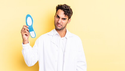 Wall Mural - hispanic handsome man feeling puzzled and confused. chiropodist concept