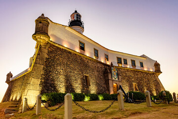 Wall Mural - Facade of famous Barra lighthouse in Salvador, Bahia during sunset in Todos os Santos bay