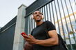 © Drobot Dean - Black sportsman listening music while standing with basketball