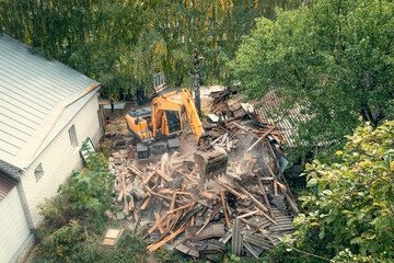 Wall Mural - Process of demolition of old building dismantling. Excavator breaking house. Destruction of dilapidated housing for new development.