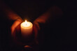 © ARVD73 - Hands holding burning candle in dark like a heart.Selective focus,black background.Copy space.