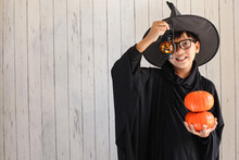 A Boy With Halloween Costume And Holding A Lantern And Pumpkin
