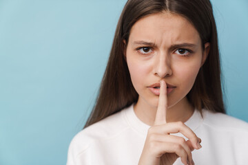 Wall Mural - Young brunette woman showing silence gesture at camera