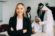© oneinchpunch - Mixed business team in Dubai. Business meeting with men wearing kandura and western people in the office