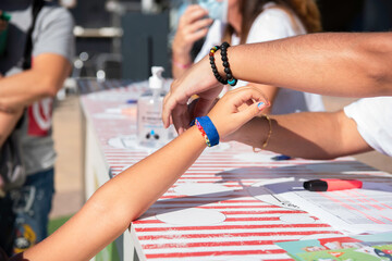 Hands of young girl putting bracelet on little Caucasian girl.