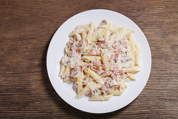 Wall Mural - plate of pasta with ham and mushrooms, top view