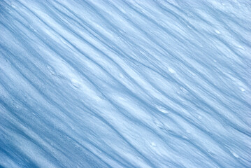 Textured snow shiny light and shadows after wind. Winter background. Abstract background, texture pattern, snowy crater, icy landscape after blizzard.