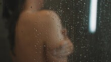 Woman Washing Herself In The Shower Behind The Glass.