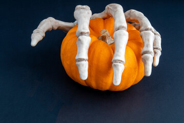 skeleton hand with pumpkin