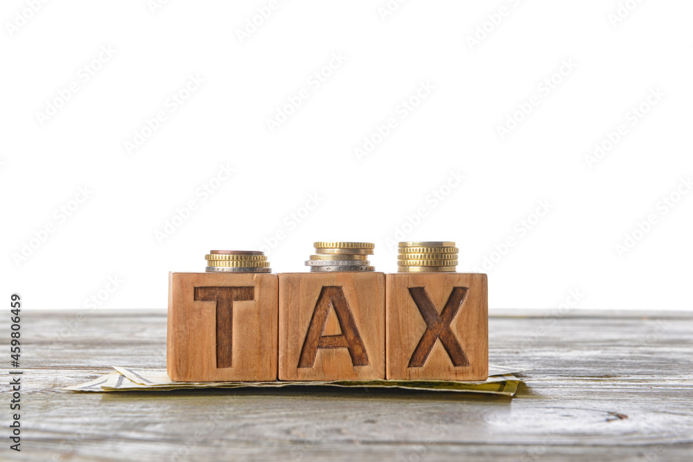 Word TAX with money on table against white background