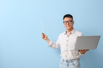 Canvas Print - Portrait of Asian teacher with laptop showing something on color background