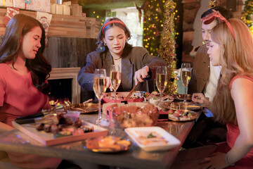 Wall Mural - Party of beautiful asian friend female and male celebrating. woman serving pizza on table with snack and drink. happiness friends christmas eve celebration dinner party food and champagne.