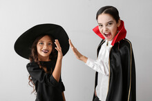 Cute Little Children In Halloween Costumes On Light Background