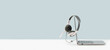 Side view of slim laptop with headphones headset on white desk. Blue background. Distant learning. working from home, online courses or support. Audio podcast. Helpdesk or call center banner
