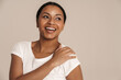 © Drobot Dean - Young black woman wearing t-shirt laughing and looking aside