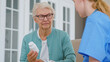 © AboutLife - Senior woman with glasses holds pills bottle in room