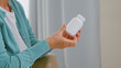 © AboutLife - Mature woman patient takes blank white bottle of medicine from doctor sitting in comfortable armchair
