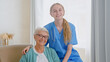 © AboutLife - Positive nurse in blue uniform comes to hug lonely senior woman sitting in comfortable armchair