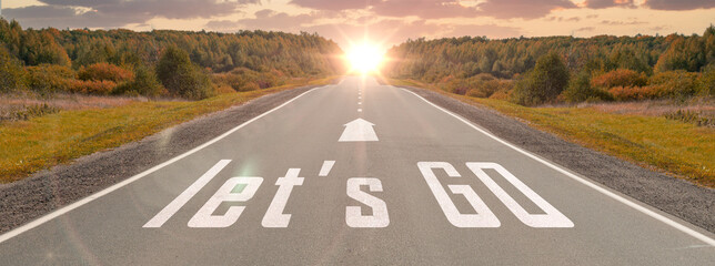 word let's go written on highway road in the middle of empty asphalt road at beautiful sunset sky. concept for business planning, strategy and challenge or career path, opportunity and change