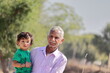 © Dinesh - portrait of A cute little boy from an Indian-origin farming family sits in his senior grandfather's womb, looking at the camera
