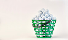 Basket Full Of Golf Balls Ready To Be Used On The Driving Range. White Background.