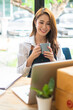 © PaeGAG - Portrait of asian young woman using laptop at cafe, she is working on laptop computer at a coffee shop.