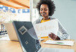 © Westend61 - Smiling female freelancer analyzing business plan at desk
