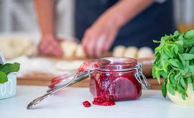 Cook hands kneading dough, piece of dough with white wheat flour. Cooks roll the dough for baking, pieces of raw dough on the wooden board.