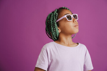 Black girl with afro pigtails wearing sunglasses posing at camera