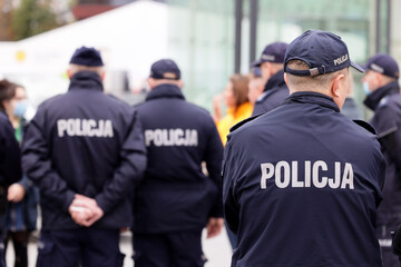 Wall Mural - Polscy policjanci w niebieskim mundurze na zabezpieczeniu imprezy w mieście.