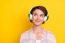 Portrait Of Attractive Cheerful Girl Deciding Copy Space Listening Bass Hit Melody Isolated Over Bright Yellow Color Background