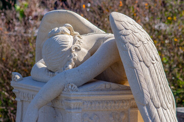 Wall Mural - Stone monument of an angel on the grave in the cemetery