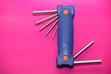 tool with set of retractable hex wrenches on pink background