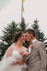 Groom hug and kiss bride in palm grove. Wedding day for two. Lovely weeding couple. Young lovers