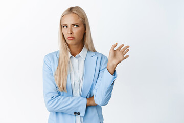 Successful businesswoman refusing uninteresting offer, wave away and roll eyes, decline something bad, standing in suit over white background