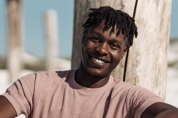 Portrait of a contented happy black man, has a warm wide smile, outdoors