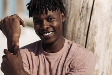 Portrait of a contented happy black man, has a warm wide smile, outdoors