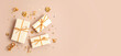 © netrun78 - Christmas background with gift boxes wrapped in golden colored paper. Xristmas celebration, preparation for winter holidays. Festive mockup, top view, flat lay